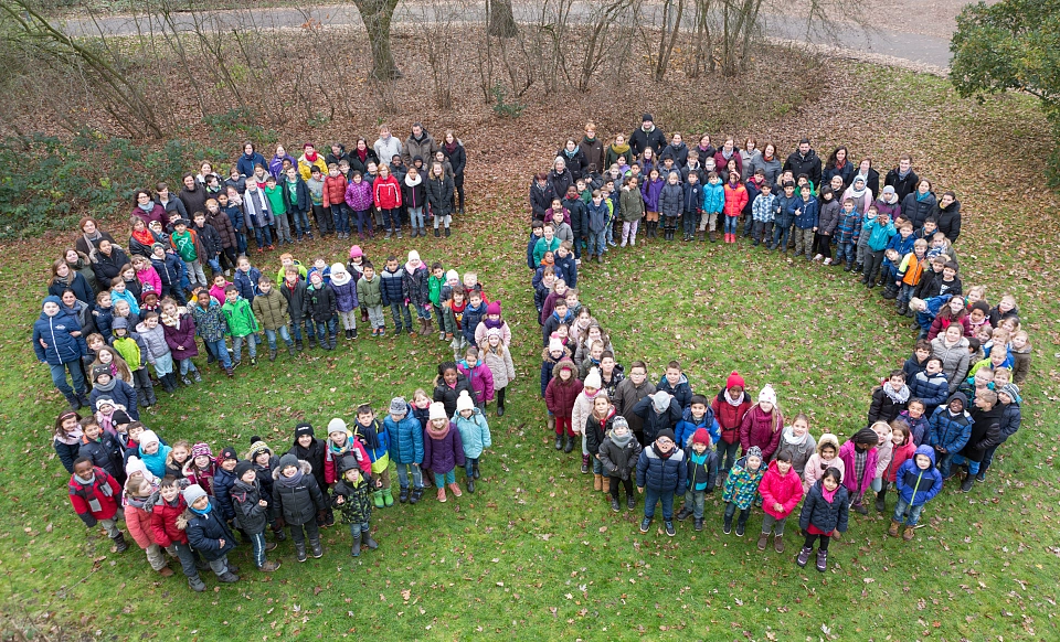 Die Sch&uuml;lerInnen und MitarbeiterInnen der Schule in der Vahr bilden eine gro&szlig;e 60 vor der Schule